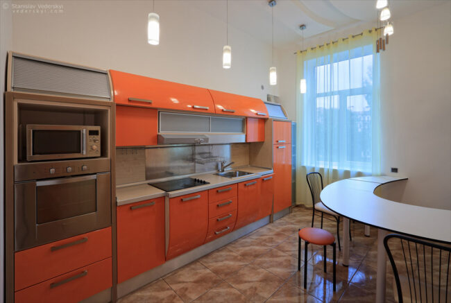 interior of the modern apartments, kitchen area design in white and orange colours. property photography