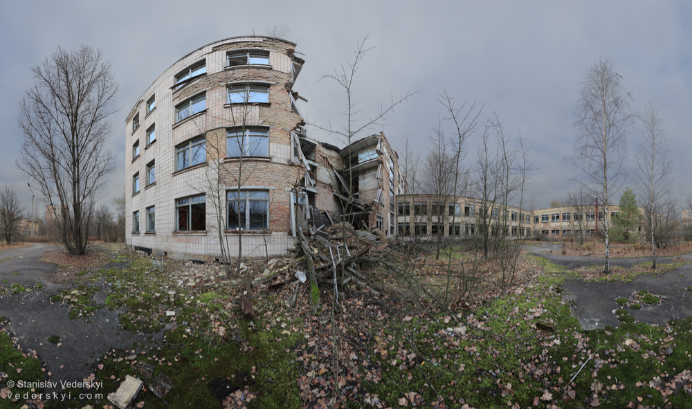 Pripyat-Ruined-School-outside-1-1000 Multirow panorama shot at the yard of derelict school with collapsed segment of the wall in abandoned Pripyat ghost town, Chernobyl zone of alienation, Ukraine.