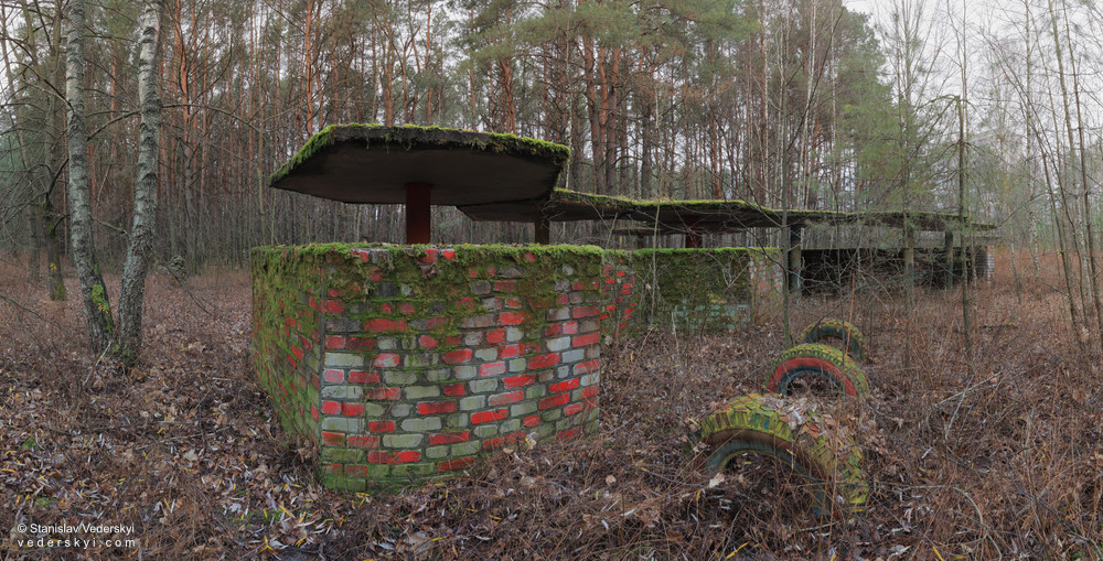 Pripyat-Playground1-1000 Chernobyl zone Multirow panorama of derelict playgroung at the verdurous yard of abandoned Pripyat ghost town in Chernobyl zone of alienation, Ukraine.