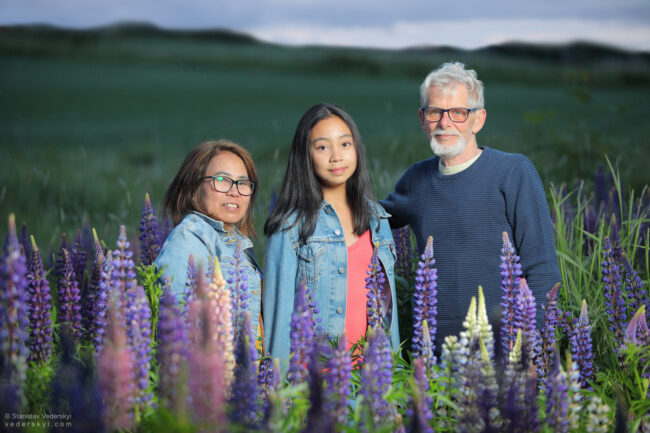 family in field with lupins at sunset time