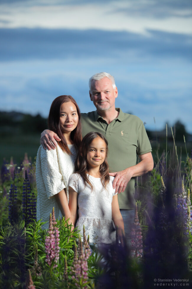 family in field with lupins at sunset time
