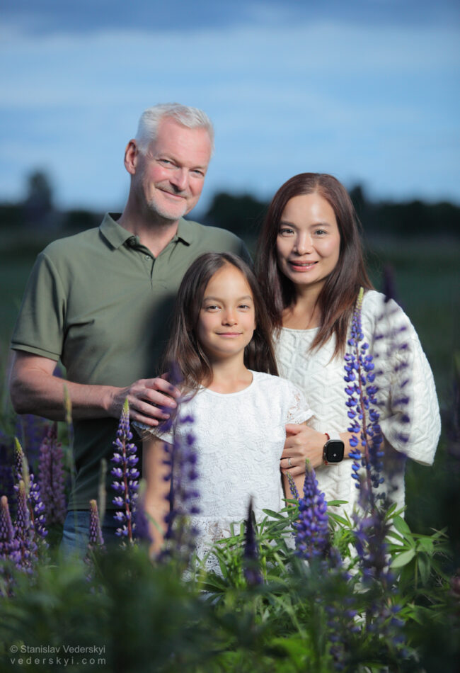family in field with lupins at sunset time